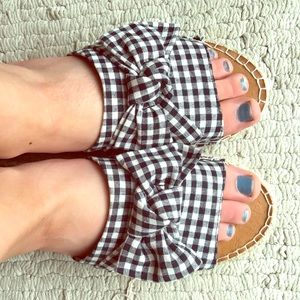Report woman’s black and white checkered slides